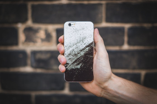 A person holding a phone with a plant-based phone case