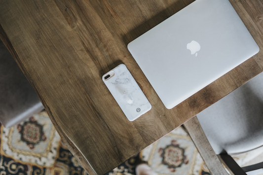 an iPhone with a marble phone cover on a table.